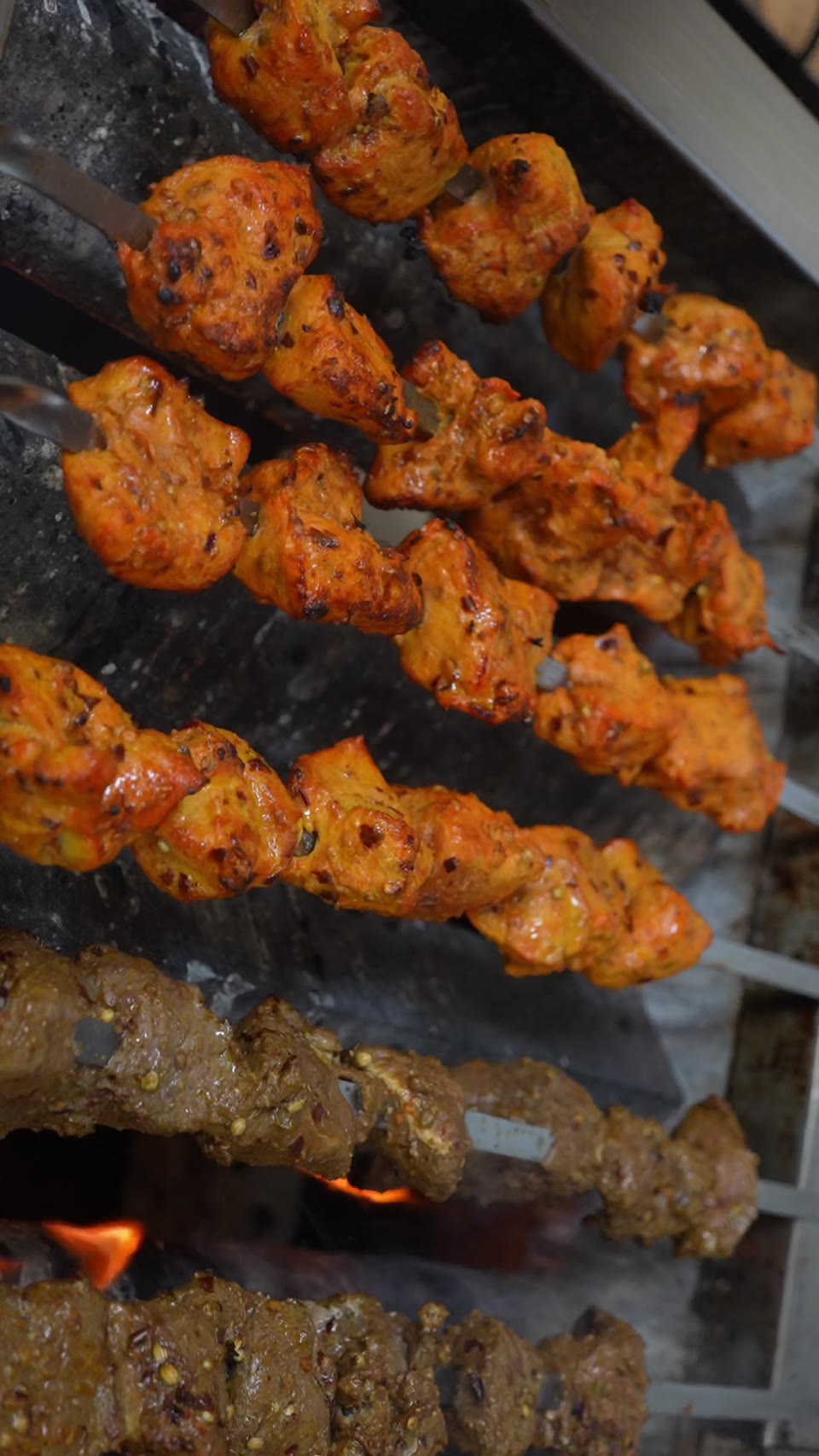 Rumi chicken and beef kabob skewers cooking over the flame